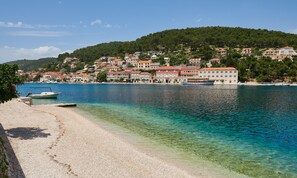 Un pueblo costero con una playa despejada y barcos.