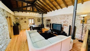 Ein gemütliches Wohnzimmer mit Steinwand, Holzboden und Kamin.