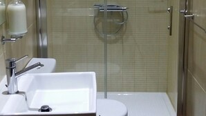 A small bathroom with a glass-enclosed shower, a sink, and a toilet. - Apartment in the heart of Vittoriosa with AC (il-Birgu)