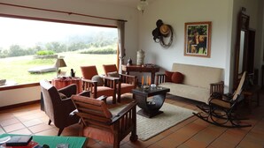 Un salón espacioso con un amplio ventanal, una chimenea y un sofá.