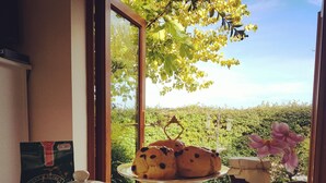 A table with a teapot, cups, a plate with pastries, a jar of jam, and a box of strawberries. - Luxury studio suite at Hawthorn Farm, kingsize bed, jacuzzi bath, private garden (Canterbury)