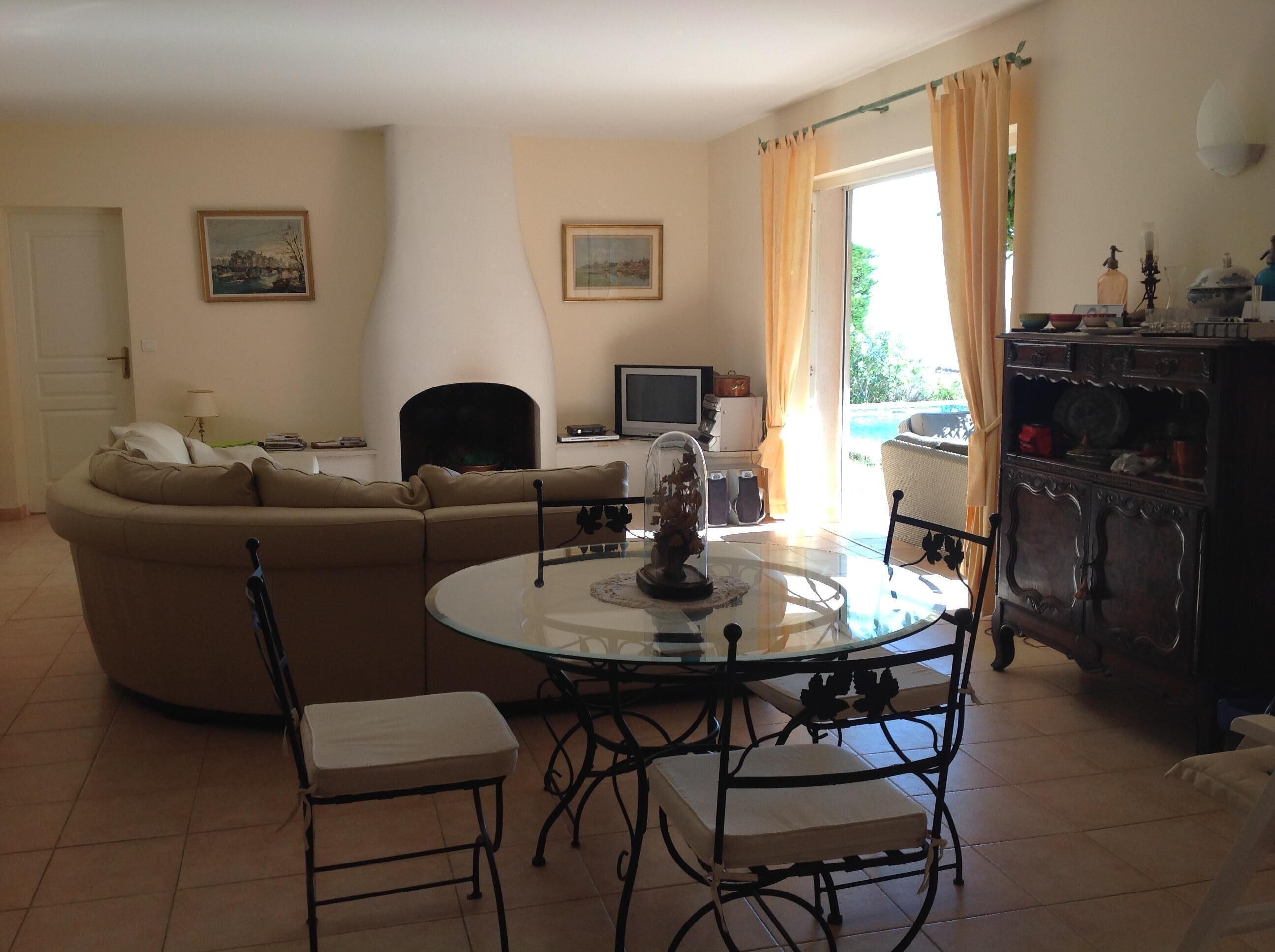 Un salon avec un canapé, une table basse en verre et un téléviseur.
