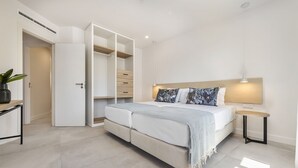 Une chambre moderne avec un lit, une table de chevet et une armoire à portes coulissantes.