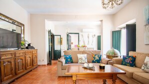 A living room with a sofa, a coffee table, a television, and a cabinet. - Self catering Puerta del Agua for 6 people (Uclés)