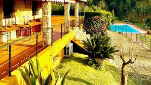 A modern house with a pool, a covered patio, and a well-maintained lawn.