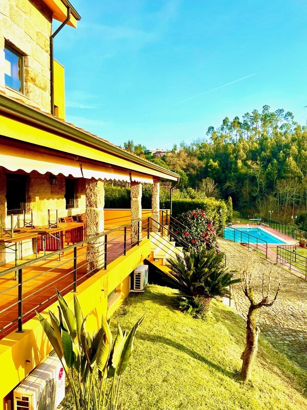 Une maison moderne dotée d’une piscine, d’un patio couvert et d’une pelouse bien entretenue.