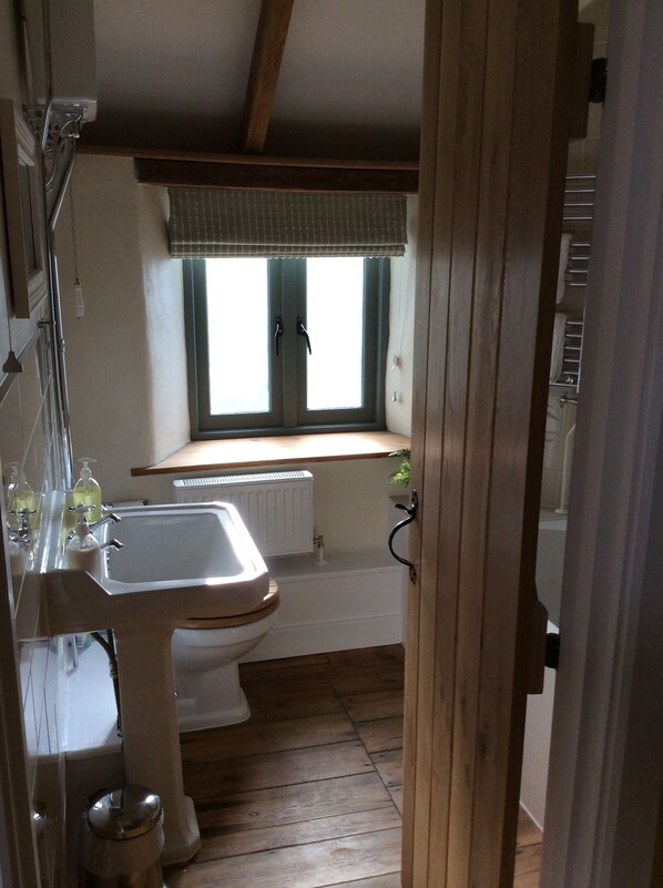 Une petite salle de bain comprenant un lavabo, des toilettes et une fenêtre.