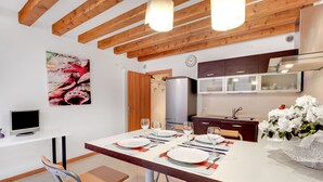 Een moderne keuken met houten balken, een eethoek voor vier personen en een groot raam.