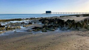 A rocky beach with a pier extending into the water. - Blackberry Cottage, Bembridge | Accessible Coastal (Bembridge)