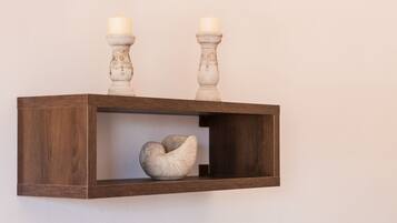 Een houten plank met twee kaarsen en een schelpen ornament.