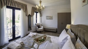 Une chambre d’hôtel comprenant un lit, une chaise, un banc, une armoire et une table à manger avec un plateau de nourriture et de boissons.
