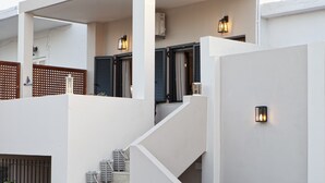 Un bâtiment moderne doté d’un escalier, de luminaires et d’une clôture en bois.