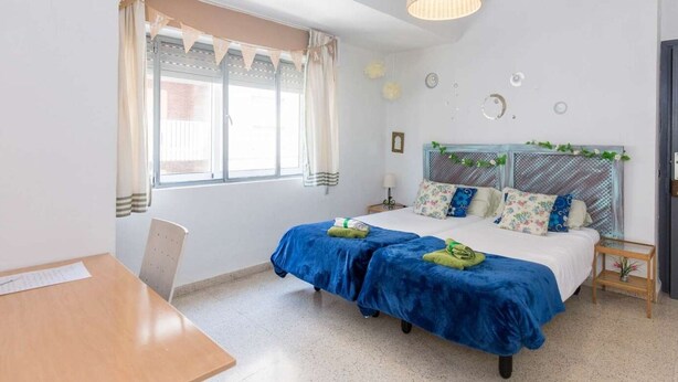 A bedroom with a bed, a desk, and a window. - Nice apartment in the city center with parking. (Granada)