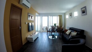 Ein modernes Wohnzimmer mit einer Couch, einem Couchtisch und einem Essbereich mit Stühlen und einem Tisch.