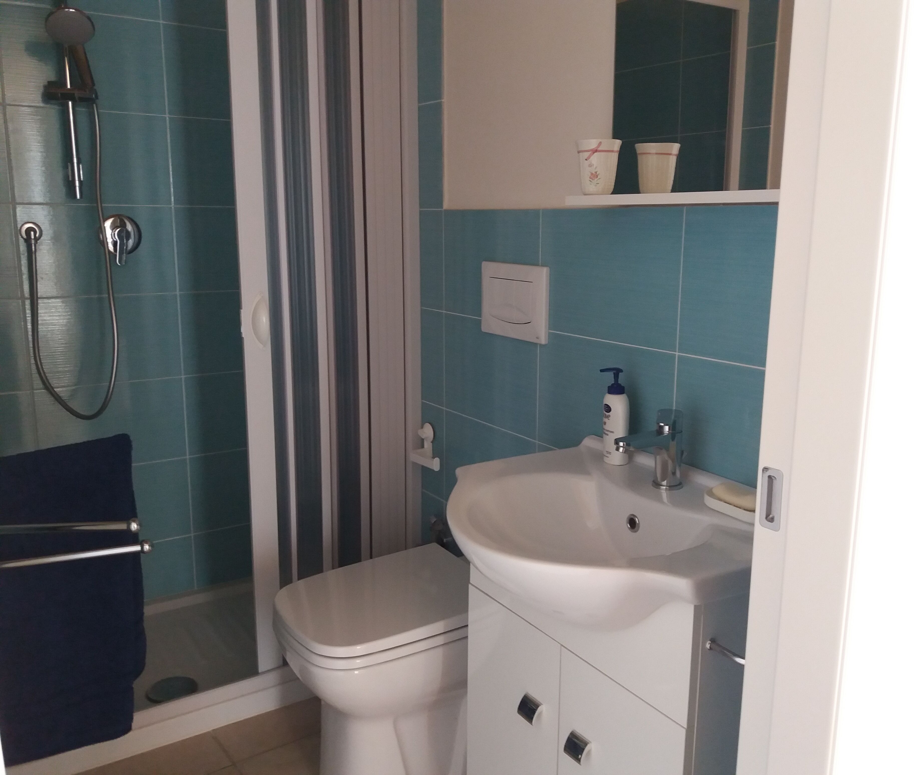 A bathroom with a shower, toilet, and sink.
