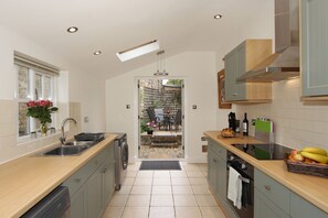 A modern kitchen with a sink, dishwasher, and a view to the outside.