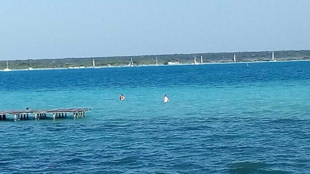 Un muelle se adentra en un mar tranquilo con cielo despejado.
