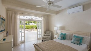 Une chambre d’hôtel avec un lit, une chaise, un bureau et un ventilateur de plafond.