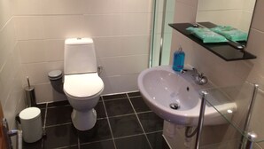 A bathroom with a toilet, sink, and a glass shower enclosure. - 1 Bedroom Chalet 30 Minute Walk From Stornoway Town Centre (Stornoway Isle of Lewis)