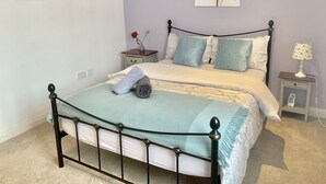 Un dormitorio con cama, mesita de noche, lámpara y decoración en la pared.