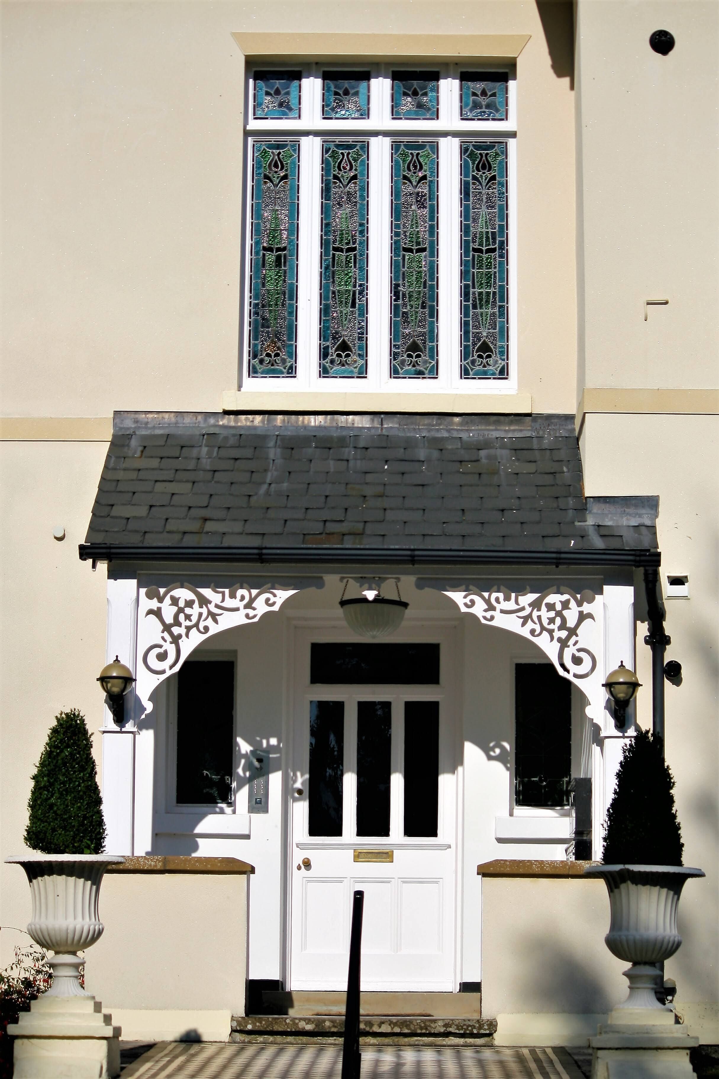 Un bâtiment à la façade blanche, au toit noir et à l’entrée ornée d’une porte blanche.