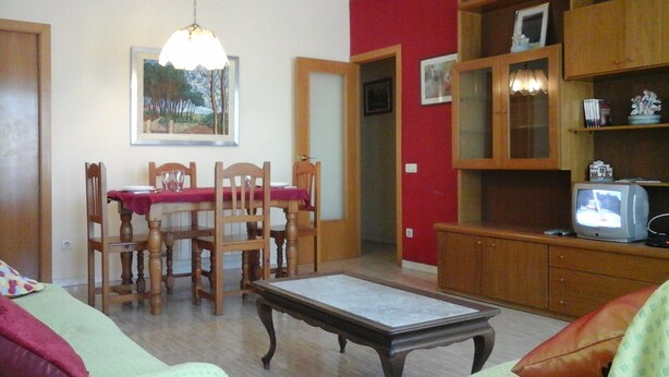 A living room with a dining table, chairs, a television, and a bookshelf. - Apartment Fira HUTB-014228 (L'Hospitalet de Llobregat)