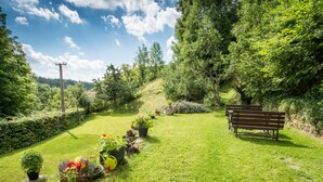 A grassy garden with a wooden bench and potted plants. - Country house Fort Lacnov (Lipovce)