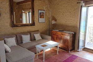 Una sala acogedora con un sofá color beige, un aparador de madera y un espejo grande.