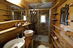 A wooden cabin bathroom with a large sink, a glass shower enclosure, and wooden shelves. - Brittany cottage "Tal ar Galonn" 4 to 10 people, welcome to the riders (Rosporden)