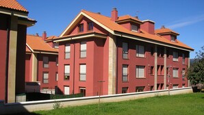 Un edificio rosso con molte finestre e un tetto in tegole.