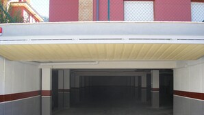Un parcheggio coperto con pavimento in cemento e ringhiere metalliche.