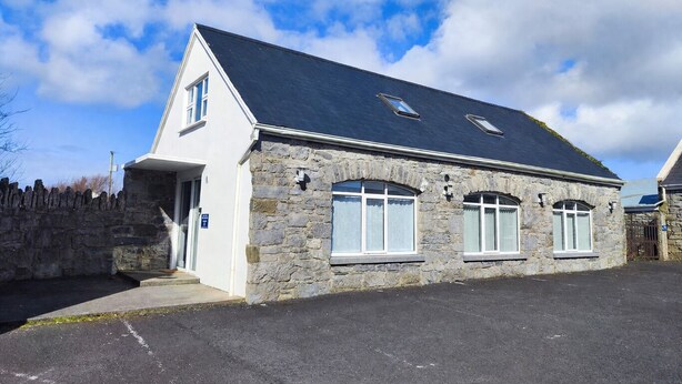 A stone building with a dark roof, white walls, and multiple windows. - Aran View Holiday Homes Doolin - The Courtyard House - Sleeps 9 (Doolin)