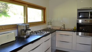 A modern kitchen with a gas stove, built-in oven, microwave, and toaster.