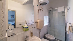 A bathroom with a toilet, sink, and shower. - Studio in the heart of Finalborgo (Finale Ligure)