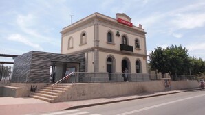 A building with a sign reading 'Pineda de Mar,' a staircase leading to an entrance, and a person walking on the sidewalk. - Spectacular Frontline, Pineda de Mar (Pineda de Mar)