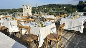 Un área de comedor al aire libre con mesas dispuestas para una comida, con vistas a un paisaje pintoresco.
