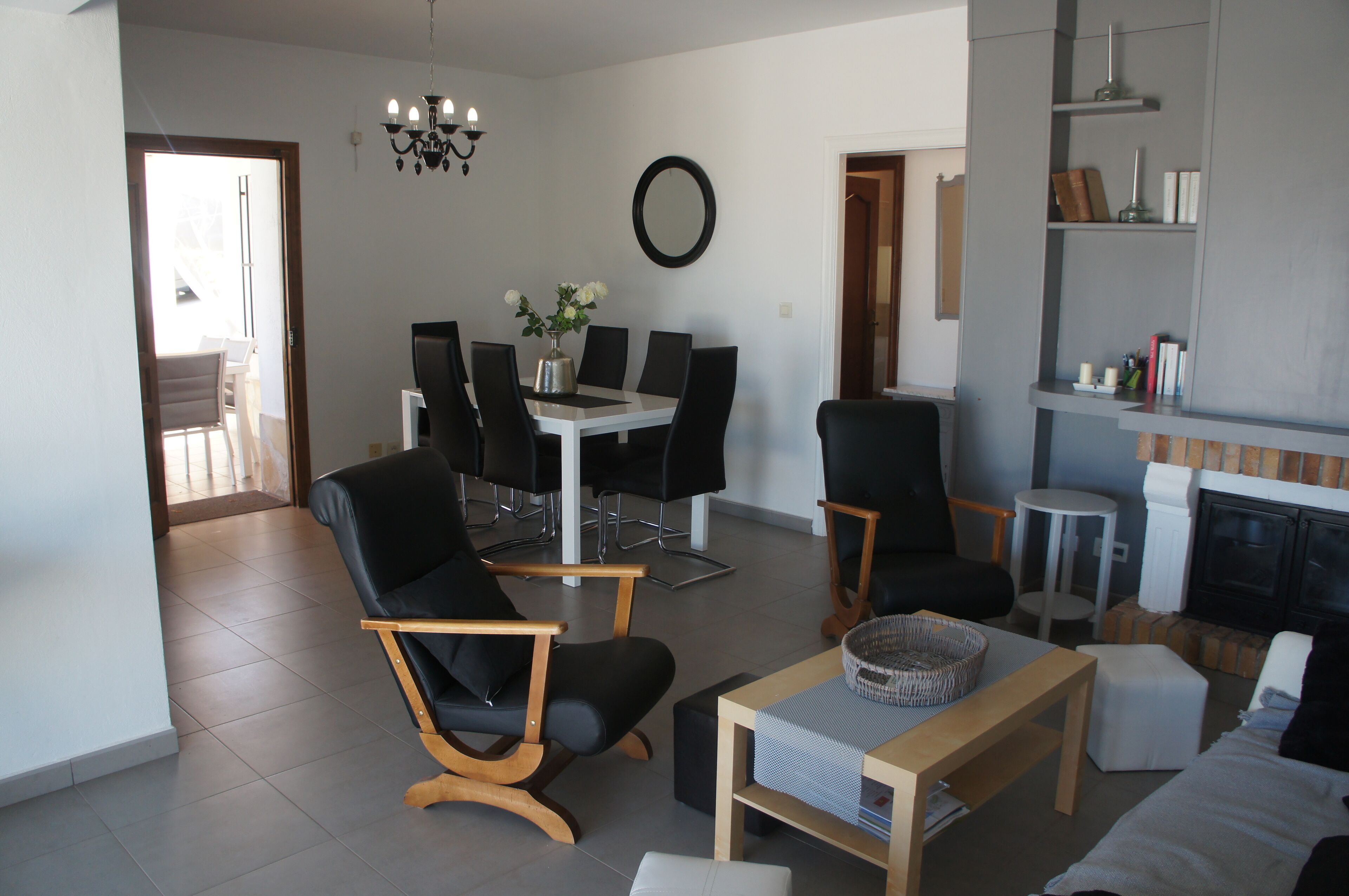 A modern living room with a dining area, a fireplace, and a view of the outside.