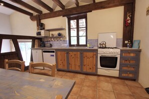 A kitchen with wooden cabinets, a stove, a microwave, and a refrigerator.
