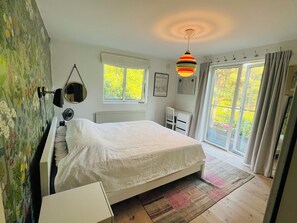 A bedroom with a bed, a radiator, a window, and a door leading to a balcony. - Top class house in the Stockholm archipelago 45 mins from City - car or bus (Stavsnäs)