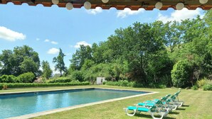 Una piscina amb una terrassa de fusta i gandules.