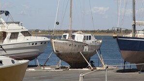 Un port de plaisance où sont amarrés plusieurs bateaux, dont un voilier et un bateau à moteur.