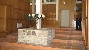 Un vestíbulo con paneles de madera, un banco de piedra y una estatua.