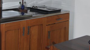 Une cuisine avec des meubles de rangement en bois, un four à micro-ondes et un évier.