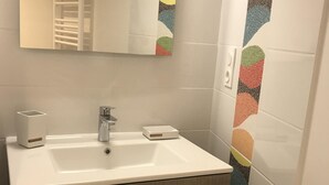 A bathroom with a white sink, a mirror, and a towel rack. - House 4 people near sea (Les Sables-d'Olonne)