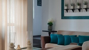 Una sala de estar moderna con sofá, una mesa de centro y un ventilador de techo.