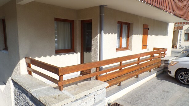 Un edificio con una escalera de piedra que lleva a un banco de madera en el exterior.