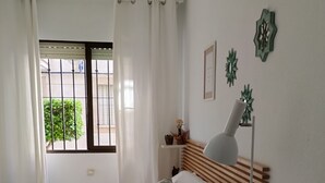 Une chambre à coucher avec un lit, une table de chevet, une lampe et une commode.