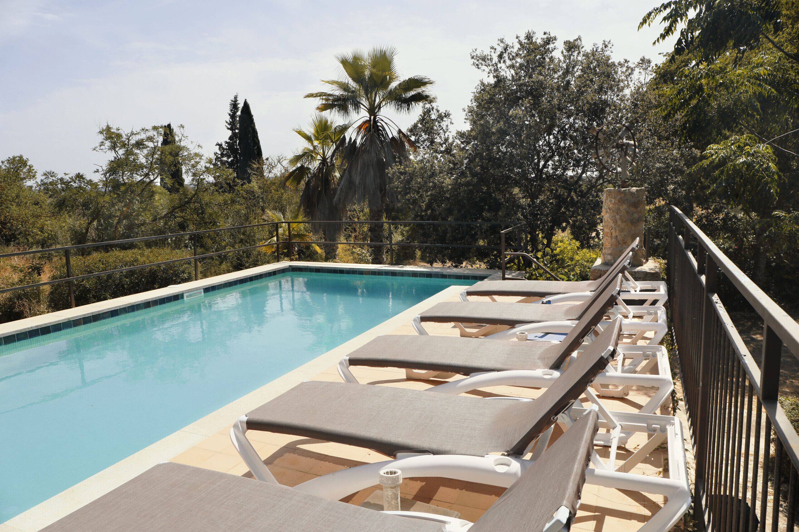 A poolside area with lounge chairs and a clear view of the pool.