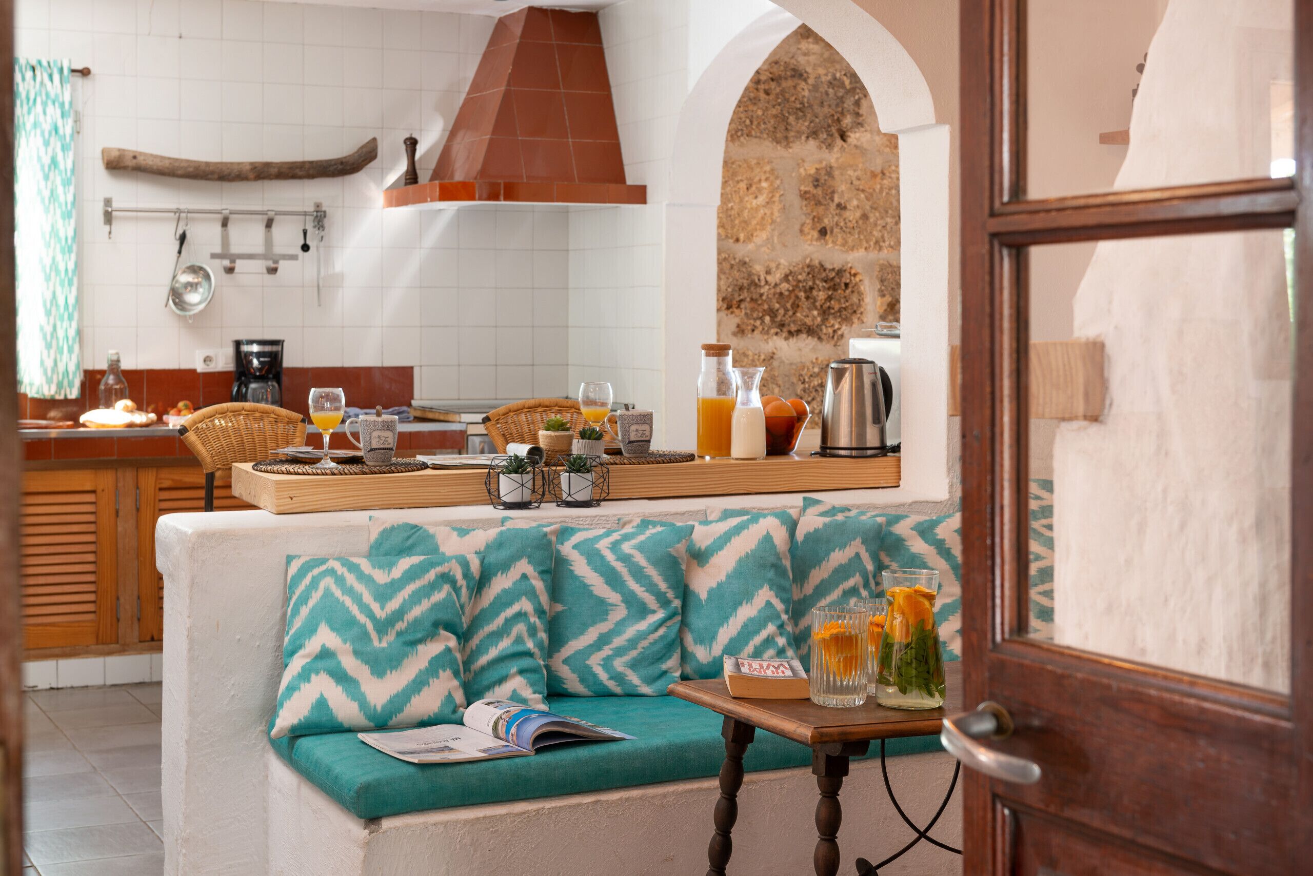 Una cocina acogedora con un banco de madera, una pared de piedra y un salpicadero de azulejos.