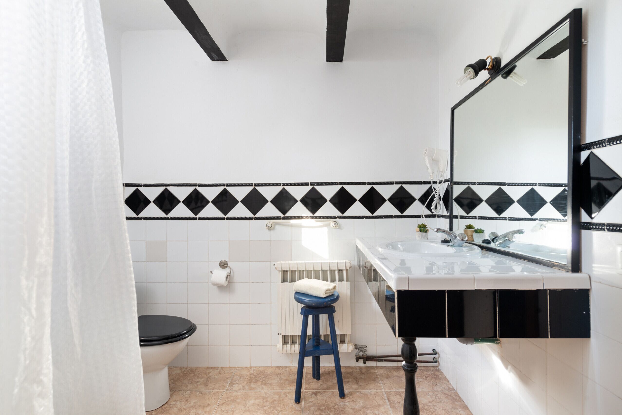 Ein Badezimmer mit Toilette, Waschbecken, Spiegel und Heizkörper.